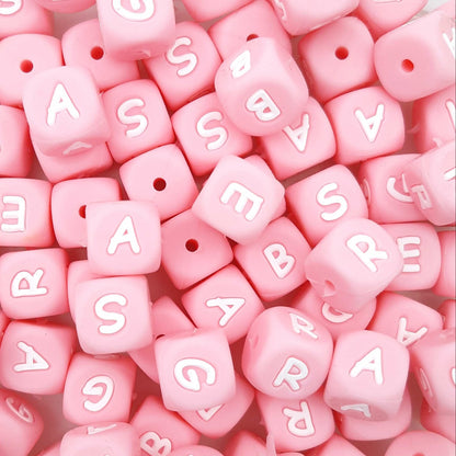 Pink letter beads with white letters scattered on a pink background